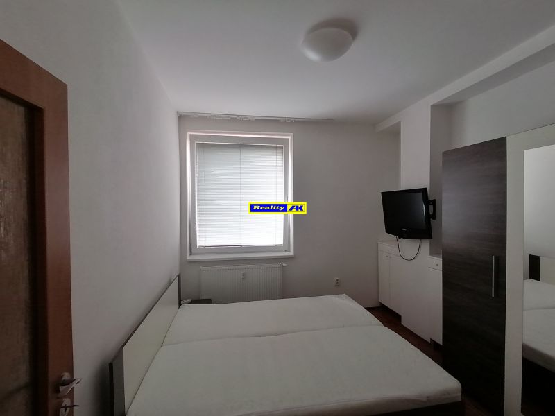 Schlafzimmer in einer 2-Zimmer-Wohnung mit Fernseher und Bett.