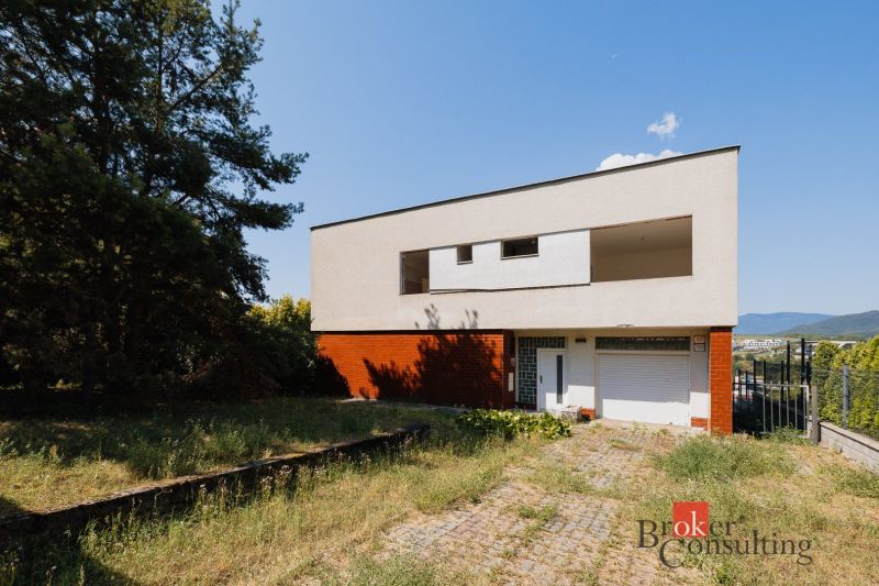 Ein Einfamilienhaus in der Komenského-Straße in Banská Bystrica mit einem großen Hof und viel Grün.