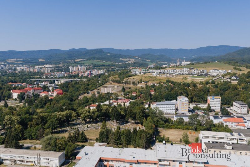 Blick auf das Panorama von Banská Bystrica von der Komenského-Straße, man sieht Einfamilienhäuser und Natur.