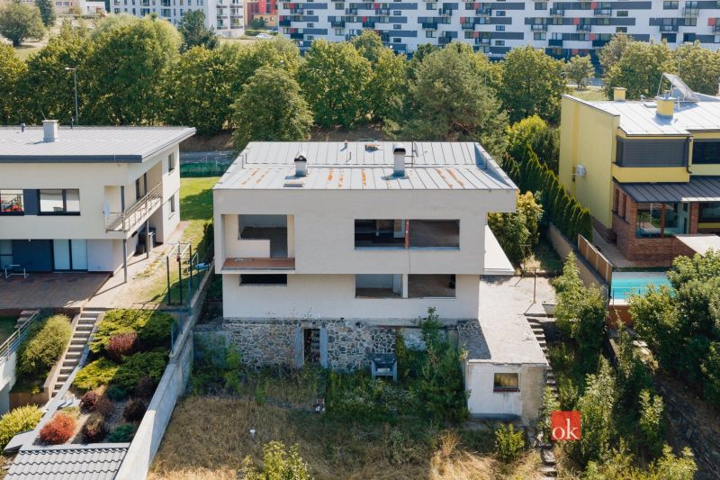 Ein Einfamilienhaus in der Komenského-Straße in Banská Bystrica, umgeben von weiteren Gebäuden und Grünflächen.