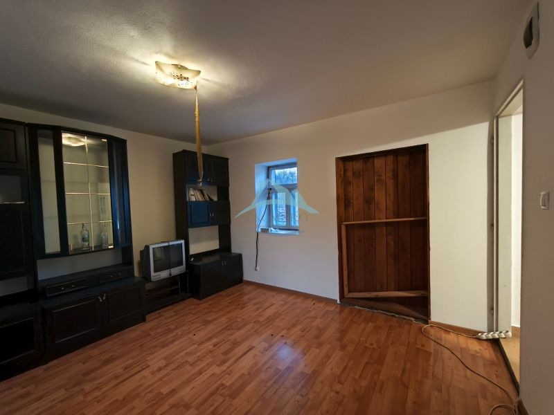 Wohnzimmer mit dunkler Wohnwand und Holzboden in einem Einfamilienhaus.