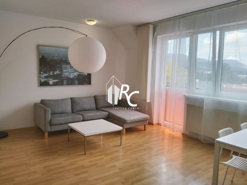 Helles Wohnzimmer in einer Zweizimmerwohnung, Sofa, Tisch, Boden mit Holzdekor.