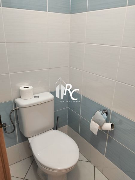 Badezimmer mit hellen Fliesen und Toilette in einer 2-Zimmer-Wohnung.