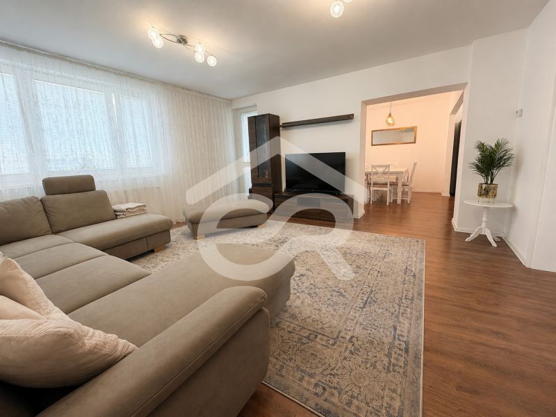 Helles Wohnzimmer mit Ecksofa und Holzboden in einem Einfamilienhaus.