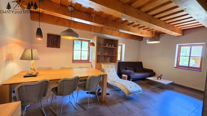 Das Innere der Hütte mit einer mit Holz verzierten Decke, bequemen Möbeln und dekorativer Beleuchtung.