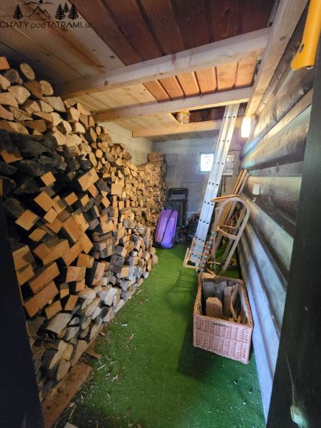 Holzinterieur der Hütte mit einem Vorrat an Holz und Werkzeugen.
