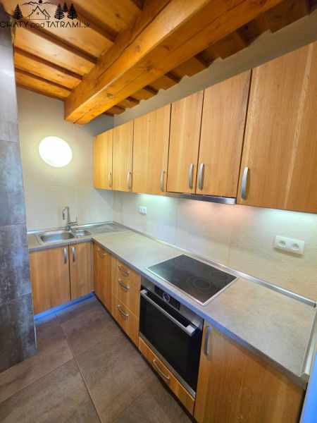 Eine Küche in einer Hütte mit einer Holzdecke und einem Boden mit Holzdekor.