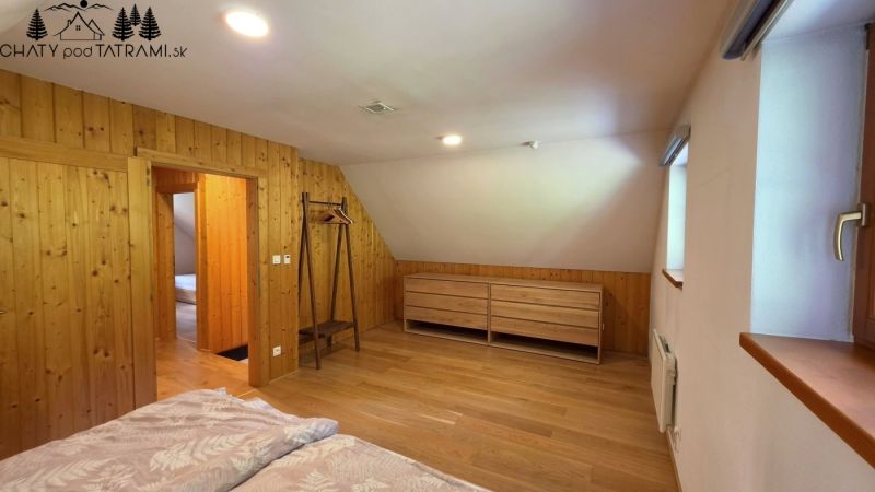 Ein Raum in einer Hütte mit einem Boden in Holzoptik, Holzverkleidung und minimalistischen Möbeln.