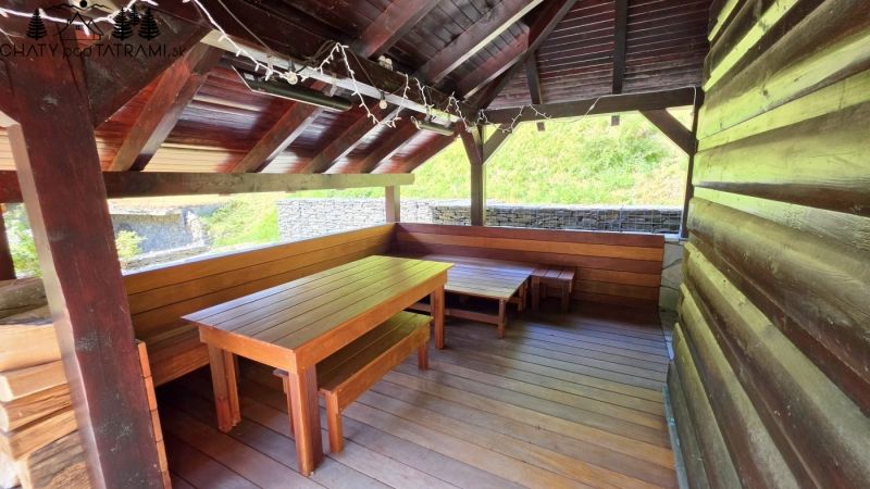 Außenbereich der Hütte in Jarabá mit einem Holzunterstand und Sitzgelegenheiten.