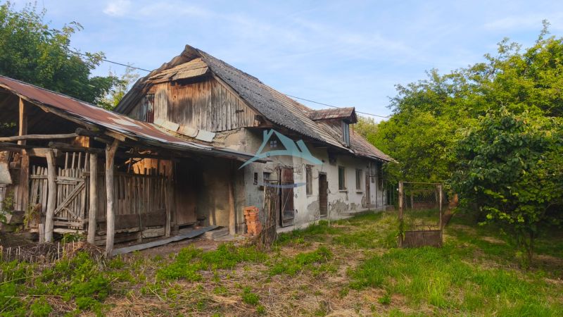 Ein älteres Einfamilienhaus in der Gemeinde Čelovce, umgeben von Grünflächen und Holzanbauten.