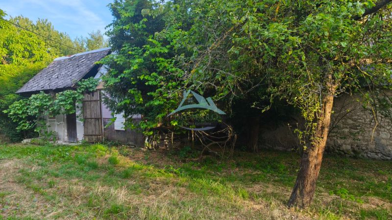 Ein Einfamilienhaus in Čelovce, umgeben von Grün und Bäumen, mit einem älteren Unterstand.