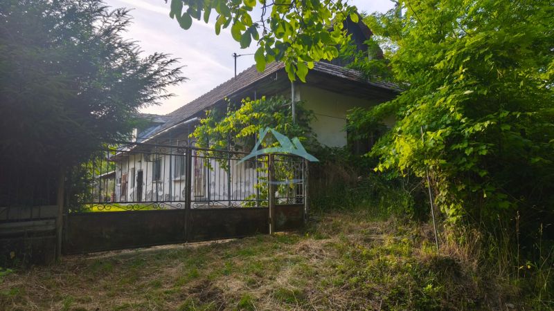Ein Einfamilienhaus in Čelovce, umgeben von Grün und einem Metallzaun.