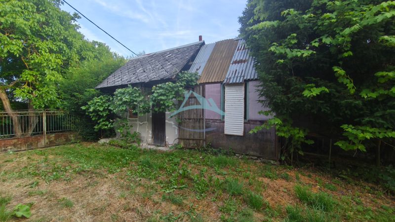 Ein älteres Familienhaus in Čelovce, umgeben von Grün und Bäumen.