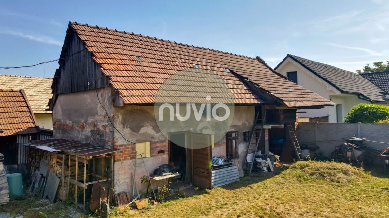 Ein Einfamilienhaus in Žabokreky mit einem ungepflegten Garten und einem Wirtschaftsgebäude auf dem Grundstück.
