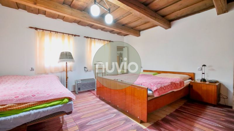 Ein Schlafzimmer in einem Einfamilienhaus mit einer Holzdecke und bequemen Betten.