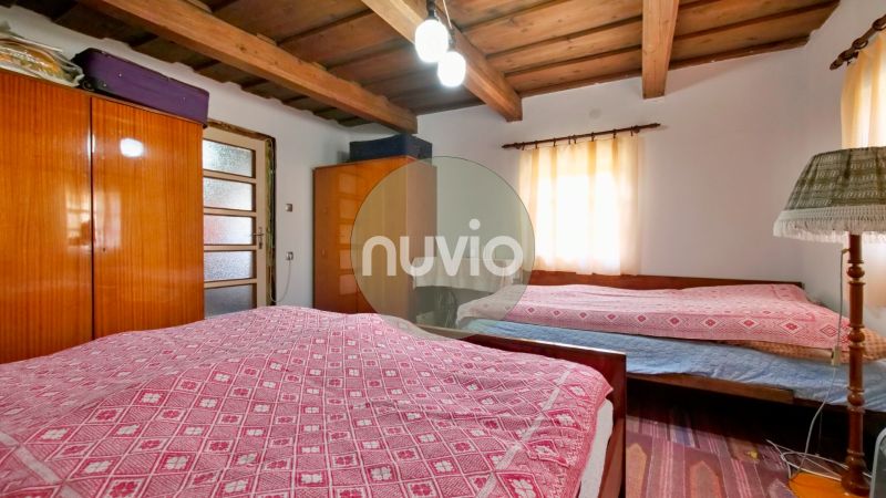Schlafzimmer in einem Einfamilienhaus mit Holzdecke, Schränken und Leuchte.