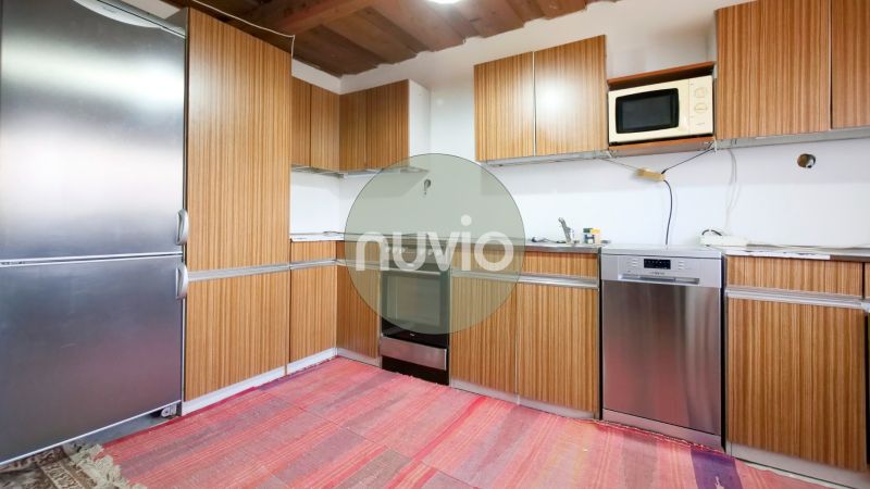 Küche in einem Einfamilienhaus mit Holzschränken und Kühlschrank.
