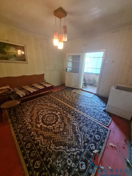 Ein Zimmer in einem Einfamilienhaus mit Teppichen, Beleuchtung und einem Sofa.