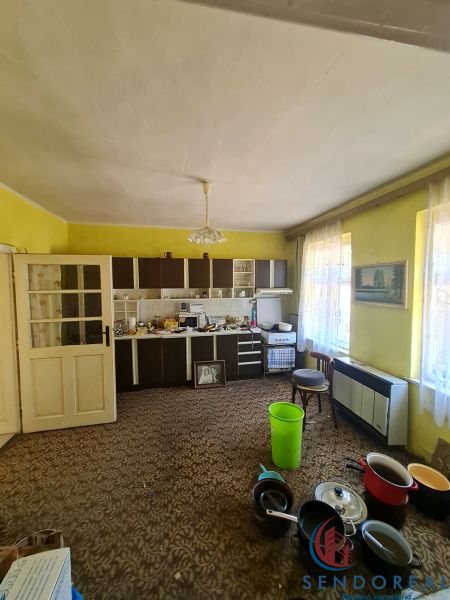 Küche in einem Einfamilienhaus mit gelben Wänden, braunem Teppich und Küchenzeile in Dolné Otrokovce.