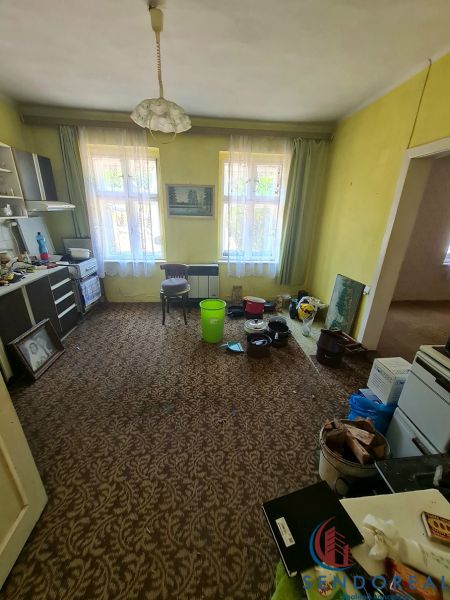 Wohnzimmer mit Teppichdekor, Möbeln und Plastikeimern in einem Einfamilienhaus.