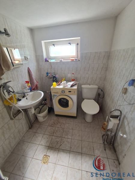Kúpeľňa v rodinnom dome s práčkou, umývadlom a toaletou, dostupné príslušenstvo.

Badezimmer in einem Einfamilienhaus mit Waschmaschine, Waschbecken und Toilette, verfügbares Zubehör.