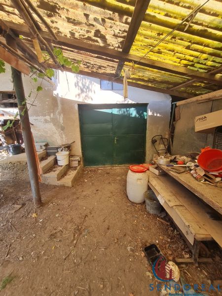 Garage bei einem Einfamilienhaus in Dolné Otrokovce mit einem Blechtor und einem Unterstand.