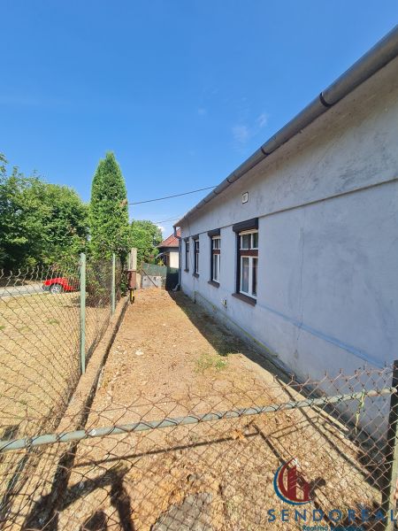 Ein Einfamilienhaus in Dolné Otrokovce mit einem Zaun und einer Zufahrtsstraße im Hof.