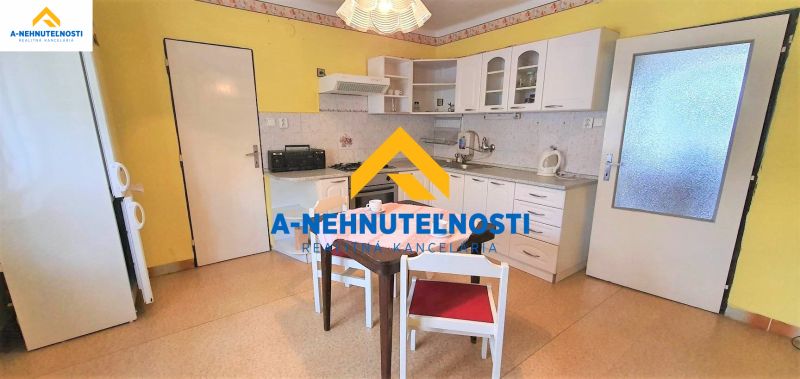 Küche in einem Einfamilienhaus mit weißen Schränken und Esstisch.