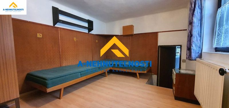 Innenraum eines Einfamilienhauses mit Bett und Boden in Holzoptik.