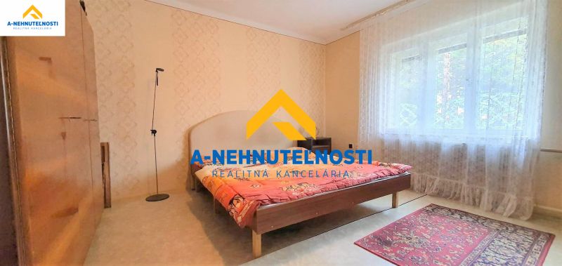 Ein Schlafzimmer in einem Einfamilienhaus mit rotem Teppich und großem Fenster.