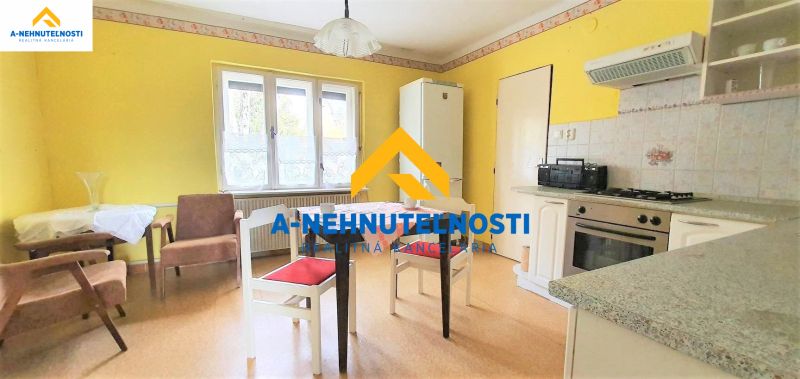 Küche in einem Einfamilienhaus mit Holzboden und gelben Wänden.