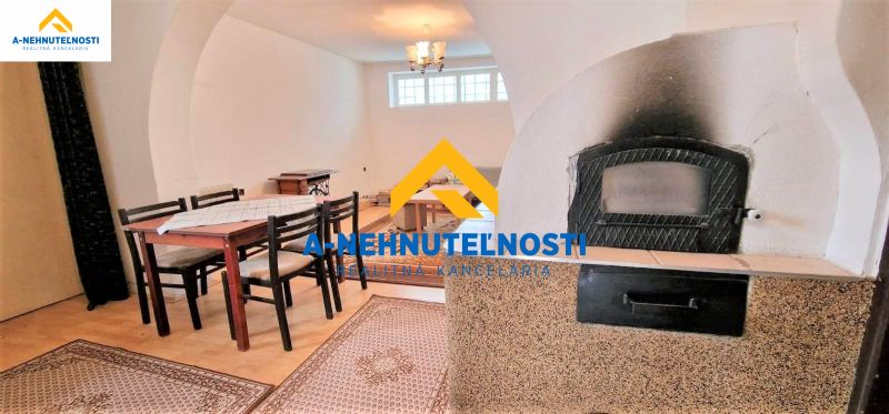 Innenraum eines Einfamilienhauses mit Esstisch, Boden mit Holzdekor, Kamin.