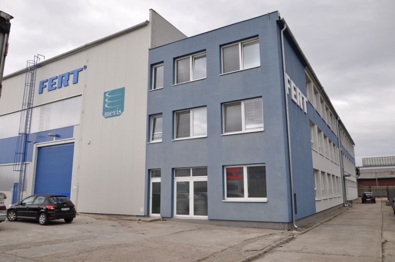 Produktionsräume in der Priemyselná-Straße in Galanta mit einem grauen Gebäude und einem Parkplatz.