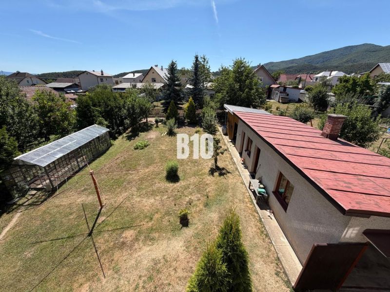 Ein Einfamilienhaus in Kláštor pod Znievom mit einem geräumigen Garten und einem Gewächshaus.