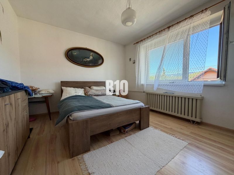Schlafzimmer mit Bett und Holzboden in einem Einfamilienhaus.
