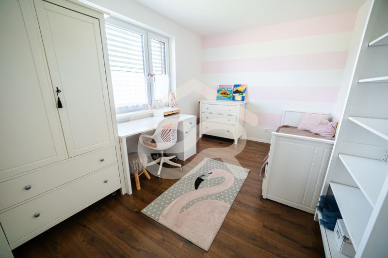 Kinderzimmer mit weißen Möbeln und Holzboden in einem Einfamilienhaus.