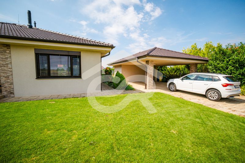 Einfamilienhaus in der Družstevná-Straße in Vráble mit Auto und überdachtem Parkplatz.