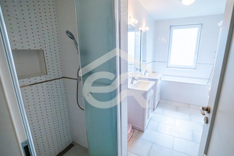 Badezimmer in einem Einfamilienhaus mit Badewanne, Dusche und Waschbecken.
