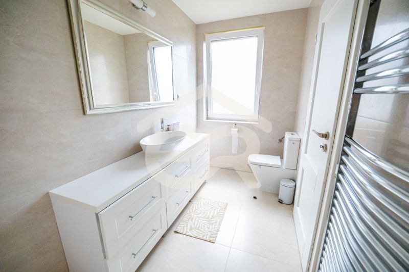 Ein Badezimmer in einem Einfamilienhaus mit einem weißen Waschbecken und einem großen Spiegel.