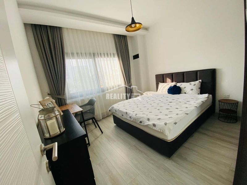 Schlafzimmer mit Bett, Schreibtisch und Holzboden in einem Einfamilienhaus.
