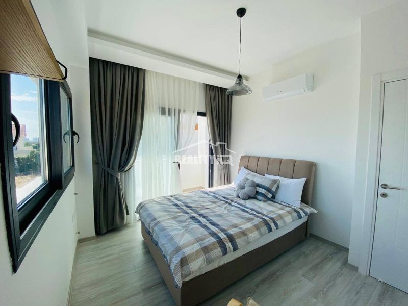 Schlafzimmer mit großem Fenster, Vorhängen und Holzboden in einem Einfamilienhaus.