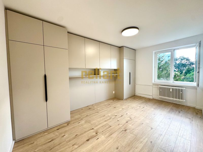 Ein Zimmer in einer 3-Zimmer-Wohnung mit geräumigen Schränken und einem Boden in Holzoptik.