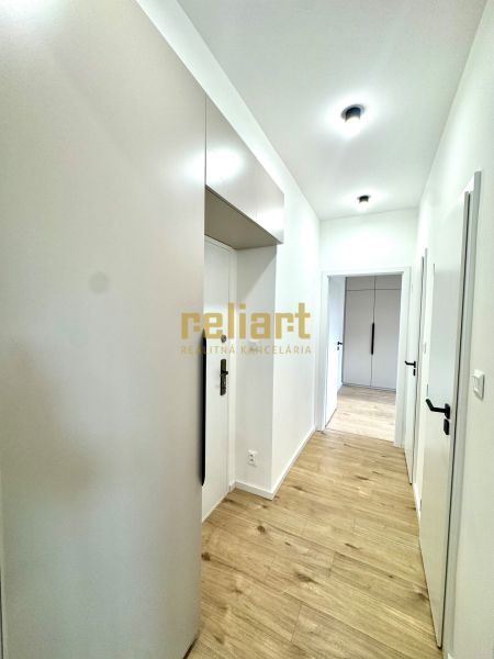 Der Flur in der 3-Zimmer-Wohnung mit Holzboden und weißen Wänden.