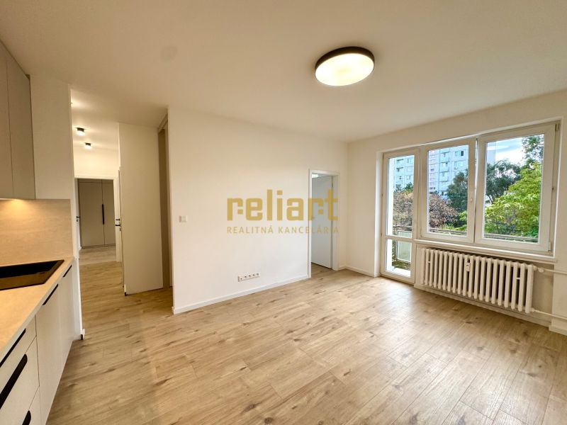 Wohnzimmer mit Holzboden in einer 3-Zimmer-Wohnung und Küchenzeile.