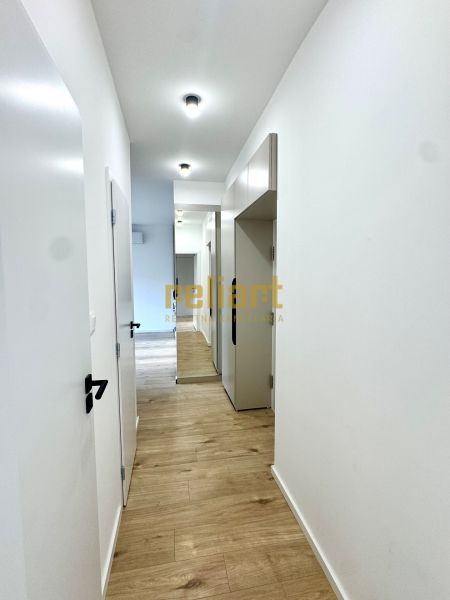Ein Flur mit hellen Wänden und einem Boden in Holzoptik in einer 3-Zimmer-Wohnung.