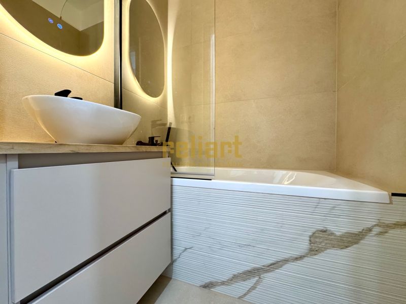 Badezimmer mit Waschbecken auf einem Schrank und Badewanne in einer 3-Zimmer-Wohnung.