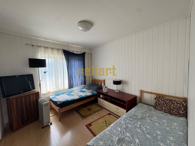 Schlafzimmer in einem Einfamilienhaus mit Betten, Fernseher und einem Boden mit Holzdekor.