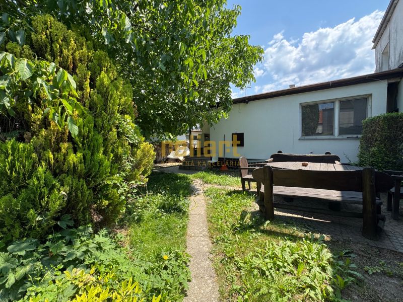 Der Garten eines Einfamilienhauses in Bratislava - Ružinov in der Senná-Straße mit einer Holzsitzgelegenheit.