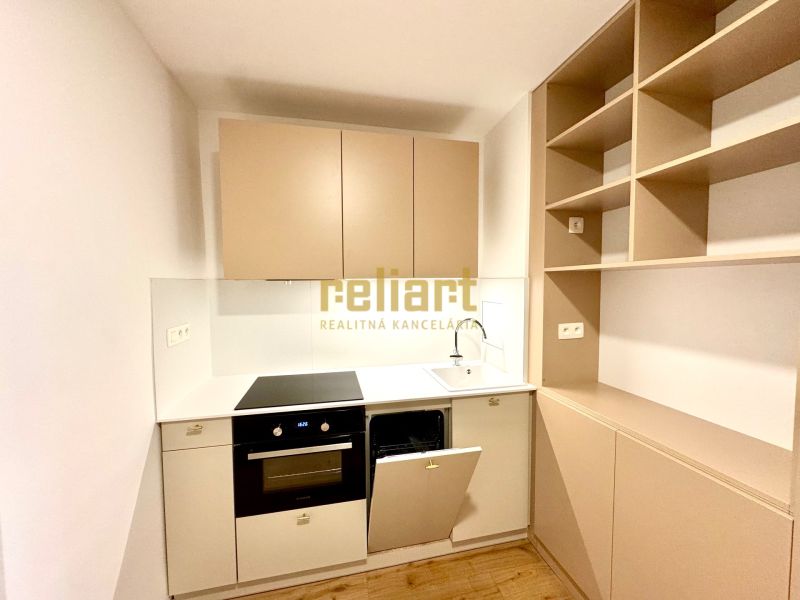 Küchenzeile in einer Einzimmerwohnung mit Holzboden, helle Schränke.