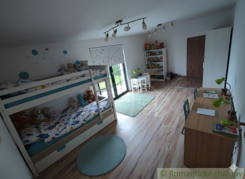 Kinderzimmer mit Etagenbett, Schreibtisch und Boden mit Holzdekor.